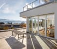 elevated room, outdoor furniture, glass sliding doors, panoramic view, tile flooring