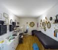 Office room with black furniture, multiple white cabinets, mirror, white walls, wooden floor, stool