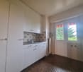 white kitchen cabinets, stainless steel sink, faucet, tiled walls, floor