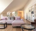 modern living room with wood floor, corner sofa, wooden coffee tables, bookshelves, light fixtures