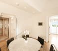 modern interior, round table, marble table top, black chairs, flower in a vase, hardwood floor, glass doors
