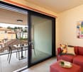 Balcony with a table, couch, pillows, book on a coffee table