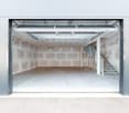 Empty garage with concrete floor, metal ceiling, and a staircase on the right side.