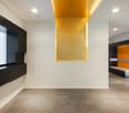 modern room, white walls, black and yellow accents, large window, tiled floor