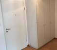 empty room, white walls, white door, built-in wardrobe with three doors, wooden floor