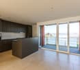 modern kitchen with an island, tile flooring, double glass door, balcony