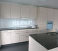 Beige cabinets, black granite countertops, stainless steel sink, gas stove, oven, faucet