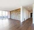 empty room, hardwood floors, white walls, brick wall, sliding glass doors, balcony