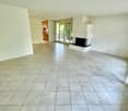empty room, white tile flooring, tall ceiling, fireplace, sliding doors, room has no furniture