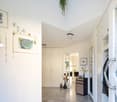 marble floor, white walls, decorative items, framed pictures, staircase, cabinet, mirror, table with flowers, chairs, and a desk