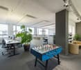 large window, desk, chairs, potted plants, foosball table, bookcase