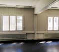 Empty room, wooden paneling, two windows, two radiators