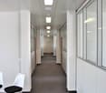 Office building hallway, white walls, gray carpet, office doors, fluorescent ceiling lights