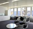 modern office room, white walls, white ceiling, white cabinets, white tables, white chairs, large windows, view of trees