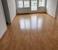 empty room, wooden floors, white walls, windows, double doors, and heater below windows