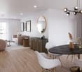Dining and living area with wooden floor, large windows, modern furniture, white walls, central round table, wall-mounted mirror, side table, plant, couch with pillows