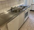 stainless steel countertop, tiled floor, wooden cabinets, built-in oven, dishwasher, kitchen sink with faucet