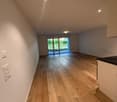 large empty room, hardwood floor, glass sliding doors, large white walls