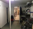 Large storage room with bicycles, tools, bags and baskets.