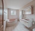 bathroom with bathtub, sink, toilet, mirror