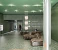 Large open lobby area with green walls, recessed lighting, and curved leather seating. The space has a modern and minimalist design aesthetic.