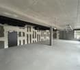 Empty room, concrete floor, unfinished walls, door, windows, pipes on ceiling