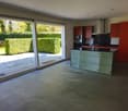 Modern kitchen with large sliding doors, kitchen island, and a view of the garden.