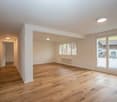 empty room, wooden floors, sliding glass doors, white walls, ceiling lights, radiator