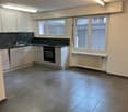 Empty kitchen with appliances, tile flooring, large windows, white cabinets, a stove, a sink, and overhead lights