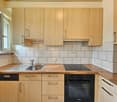 modern kitchen with oak countertops, wooden cabinets, Bosch dishwasher, Siemens washing machine, stove, sink, faucet