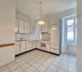 modern style kitchen, white cabinetry, white tile flooring, modern appliances, gas stove, white sink, modern faucet, built-in dishwasher