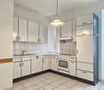 modern kitchen with white cabinets, white tiled floor, dishwasher, washing machine, gas stove, oven, sink with faucet, tiled backsplash, light fixture