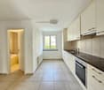 tiled flooring, modern cabinets, tiled backsplash, integrated sink, gas stove, dishwasher, washing machine, overhead light