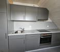 gray cabinets, granite countertop, stainless steel sink, faucet, built-in oven, power outlets