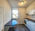 Open kitchen, granite countertop, integrated dishwasher, modern appliances, white cabinetry, black tiled backsplash