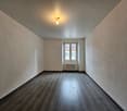 empty room, wooden floor, white walls, window with radiator