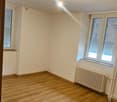 empty room with hardwood floors, white walls, windows, radiator