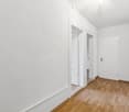 modern minimalist room with white walls, wooden floor, doors