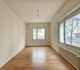 Wooden floors, white walls, two windows, radiator