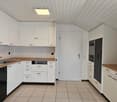 kitchen, white cabinets, stainless steel appliances, tiled floor, wooden countertops