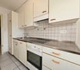 white cabinets, tile flooring, white oven and stove, silver countertop, sink, faucet