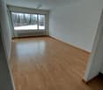 wooden floor, white walls, large window with view of trees and snowy field