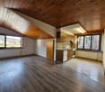 Open floor plan, wooden ceiling, wooden floor, radiator, kitchen, sink, two windows