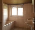 Bathroom with bathtub, two sinks, white tiles, wooden ceiling