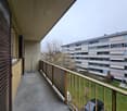 Apartment balcony, metal railing, tiled floor, parked cars