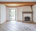 white walls, tiled floor, large open door, fireplace against a wall
