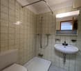 Bathroom with shower, toilet, and sink.
