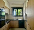 wooden cabinets, black countertops, stainless steel sink, double oven, dishwasher, window with a view