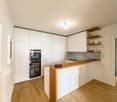kitchen with white cabinets, wooden counter, sink, built-in oven and fridge, white floors, wooden floors