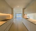 modern minimalist kitchen, induction stove, large sink, sliding glass door, balcony